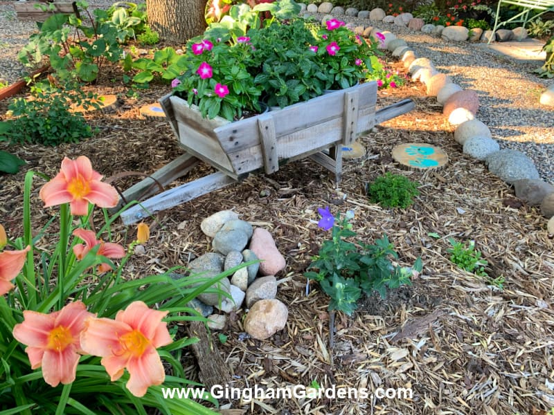 Image of a flower garden with an old barn wood cart