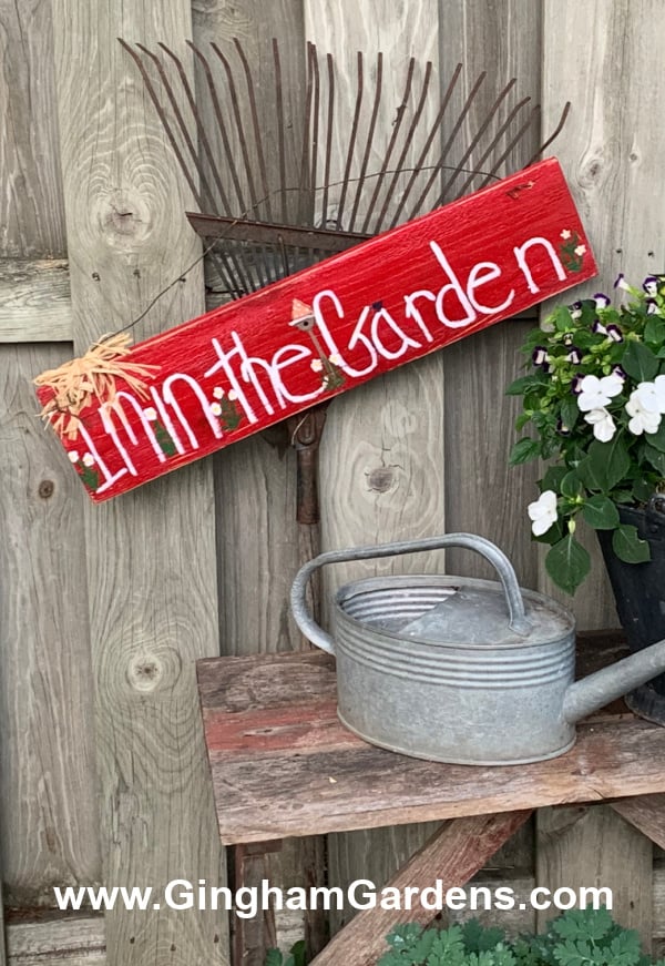 I'm in the Garden sign hanging on an old rake.
