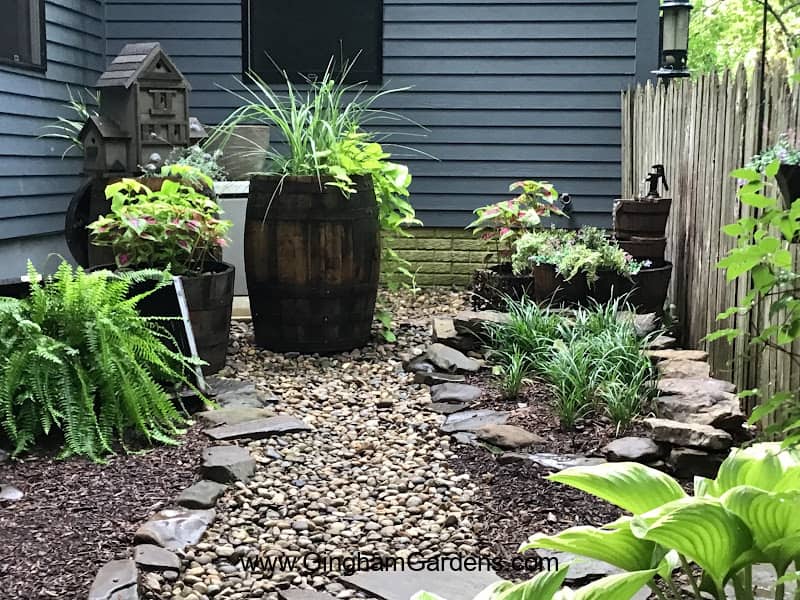 garden with whiskey barrel planters