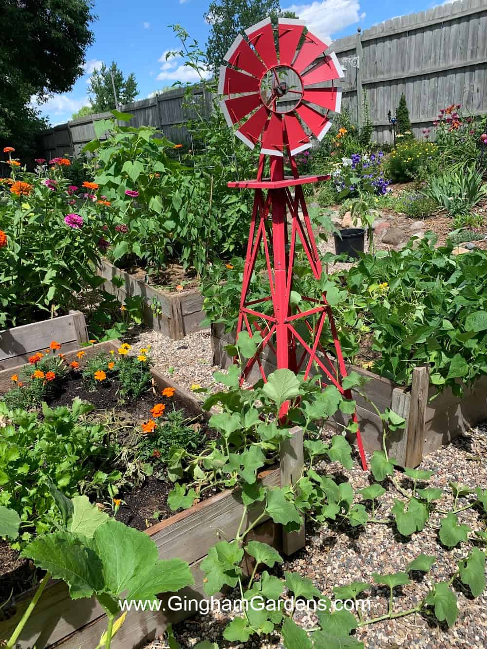 Red wind mill as a focal point in a garden.