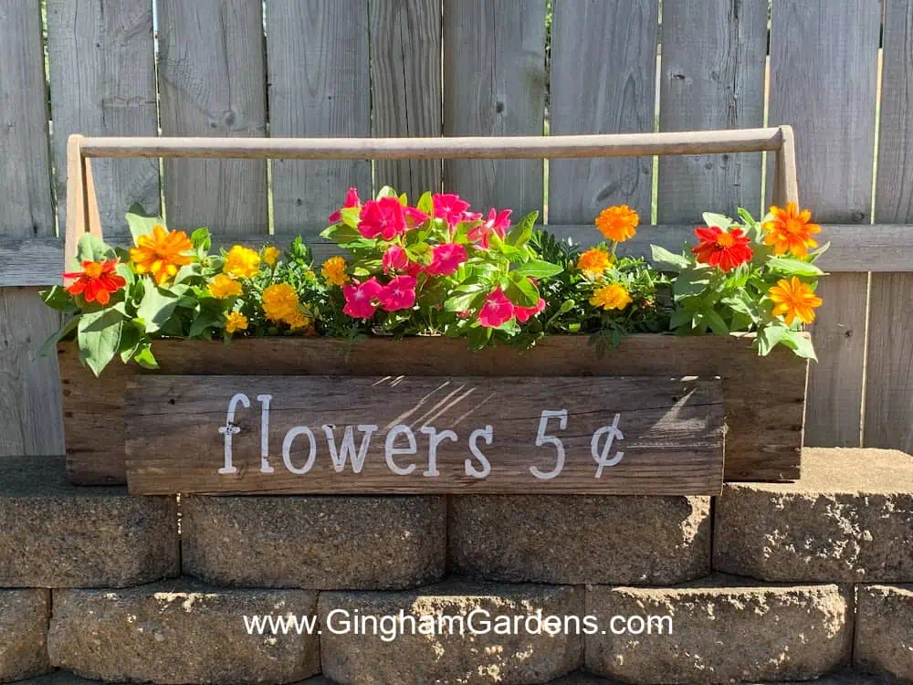 Antique tool box with flowers and a flower sign