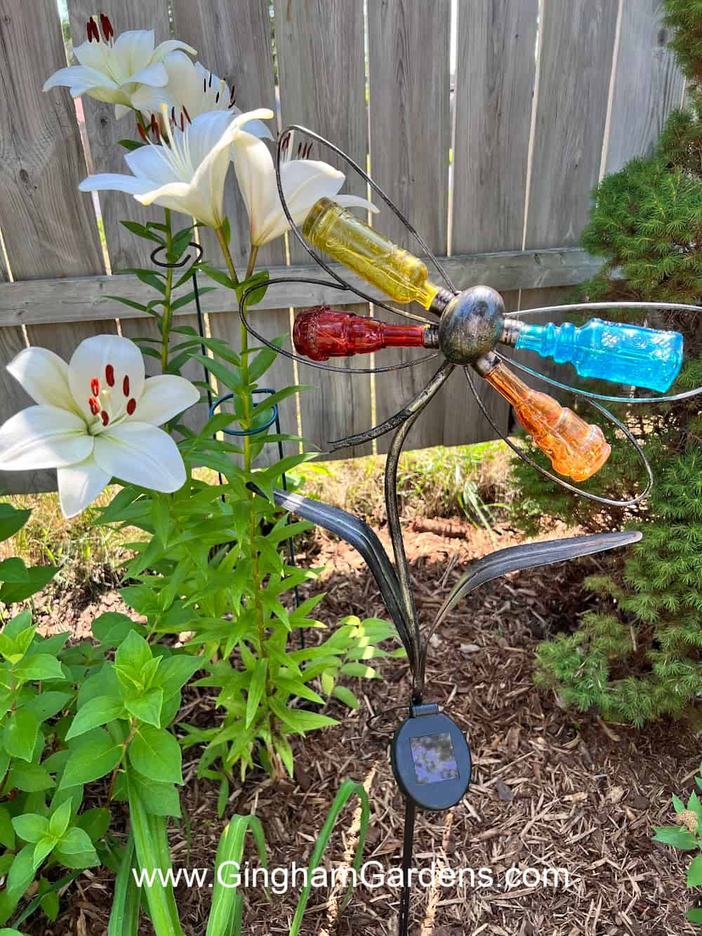 Decorative solar garden stake made with small colorful bottles in the shape of a butterfly.